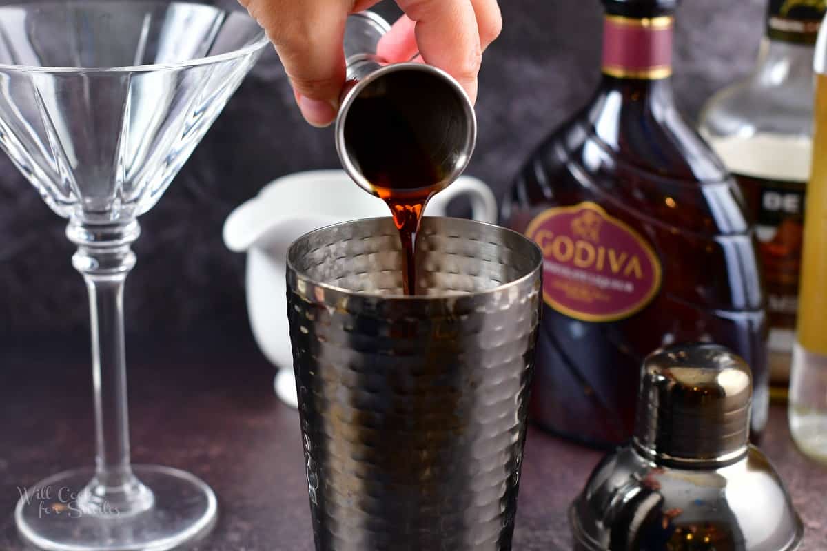 adding crème de cocoa to the cocktail shaker