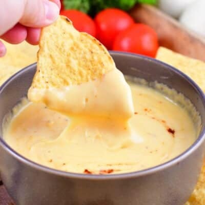 dipping tortilla chips dipped in a nacho dip