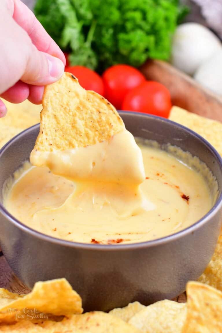 dipping tortilla chips dipped in a nacho dip