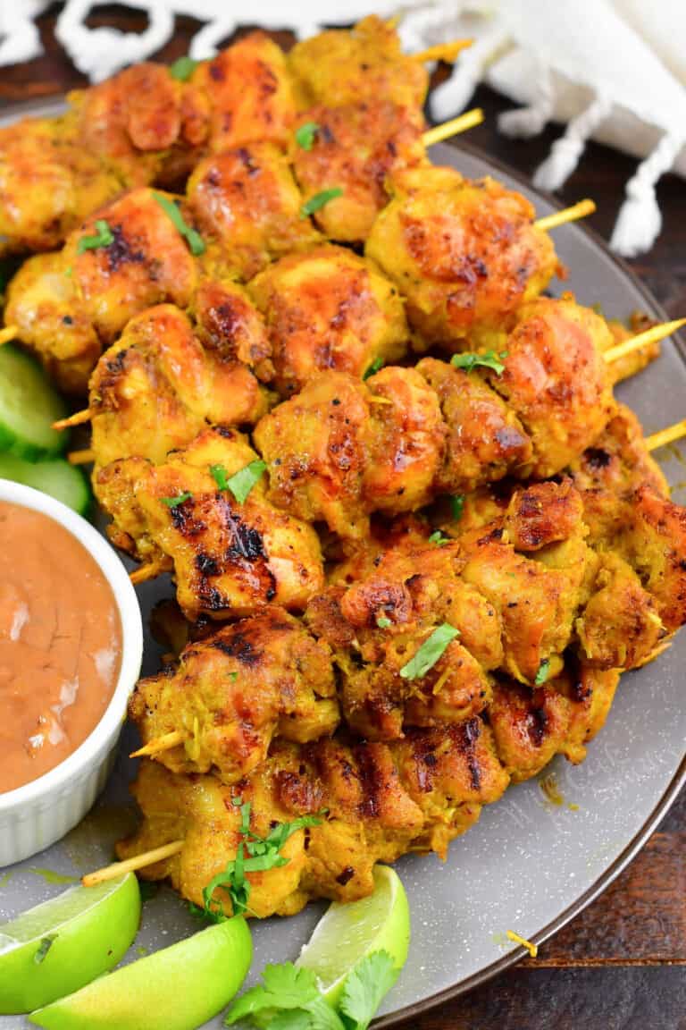 skewers of chicken satay layered on a plate