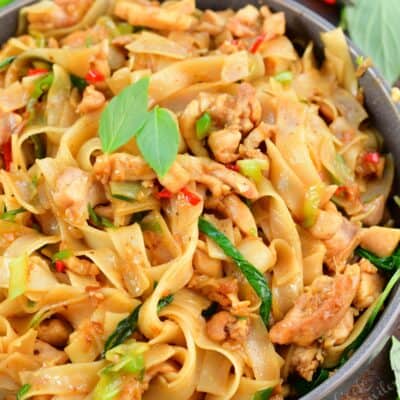 top view of drunken noodles in a bowl with veggies around