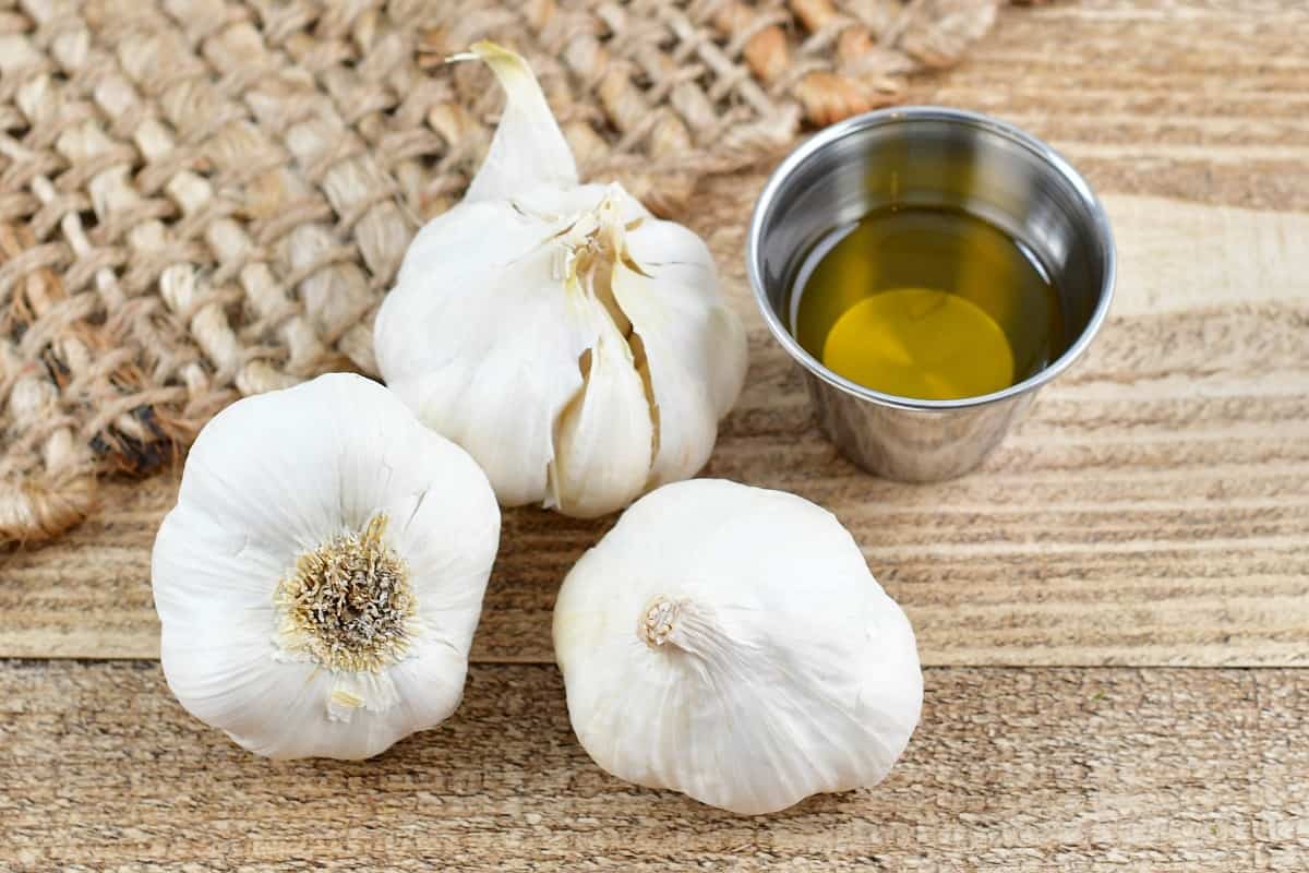 three garlic cloves and olive oil in a cup