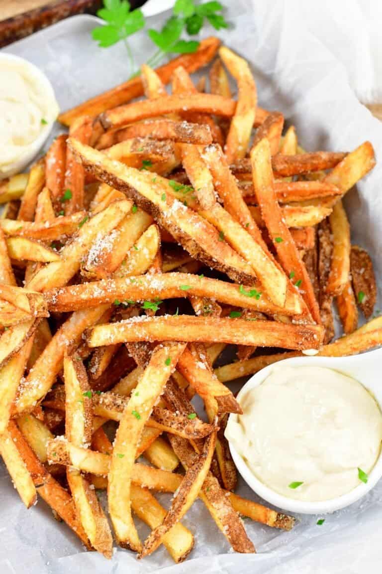 closeup of truffle fries in a basket with aioli