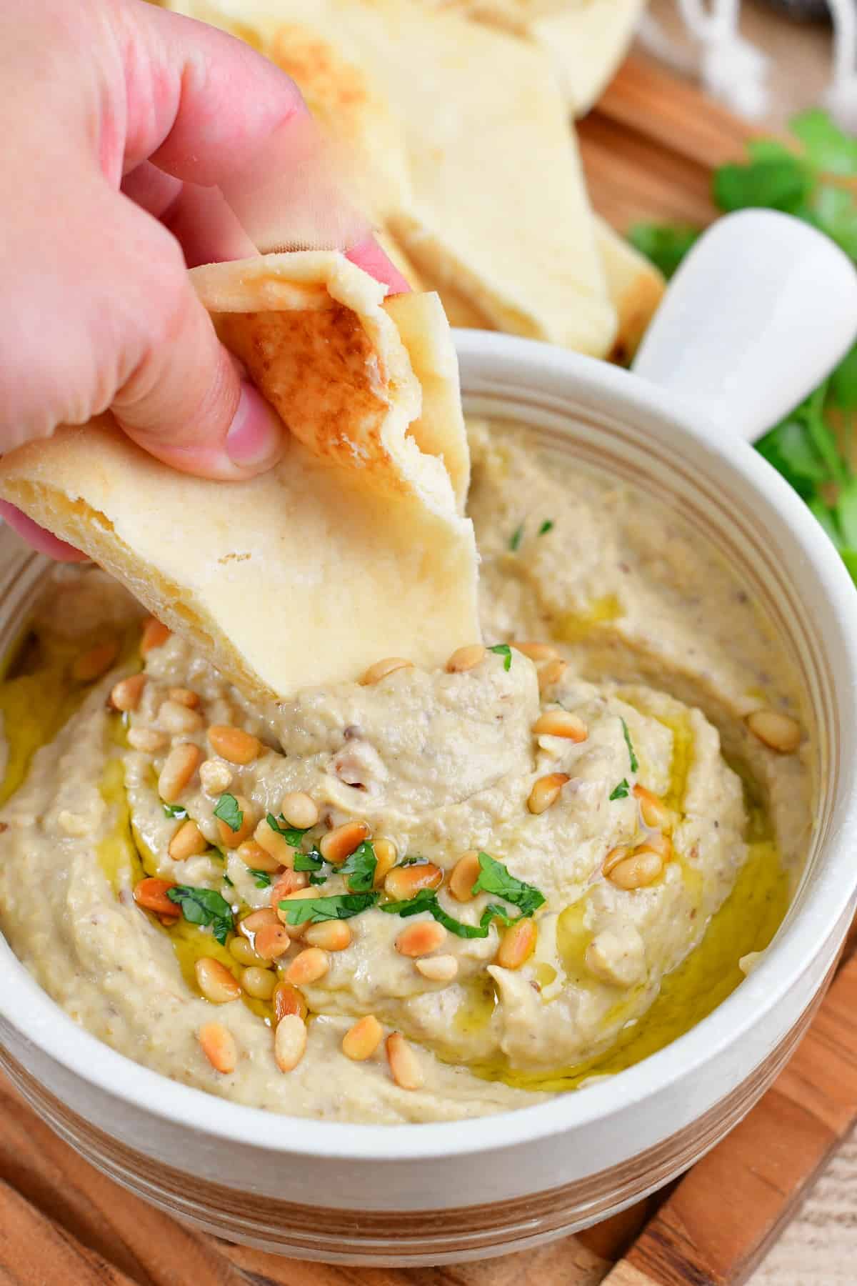 dipping into the baba ganoush dip with pita