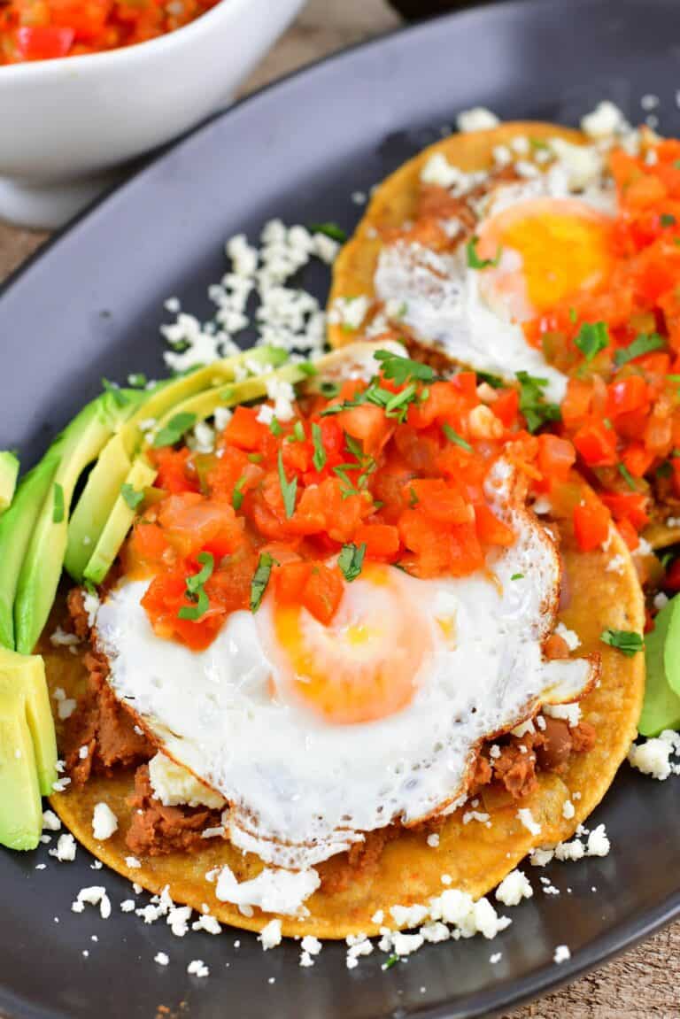 closeup view of the eggs over tortilla and tomato sauce