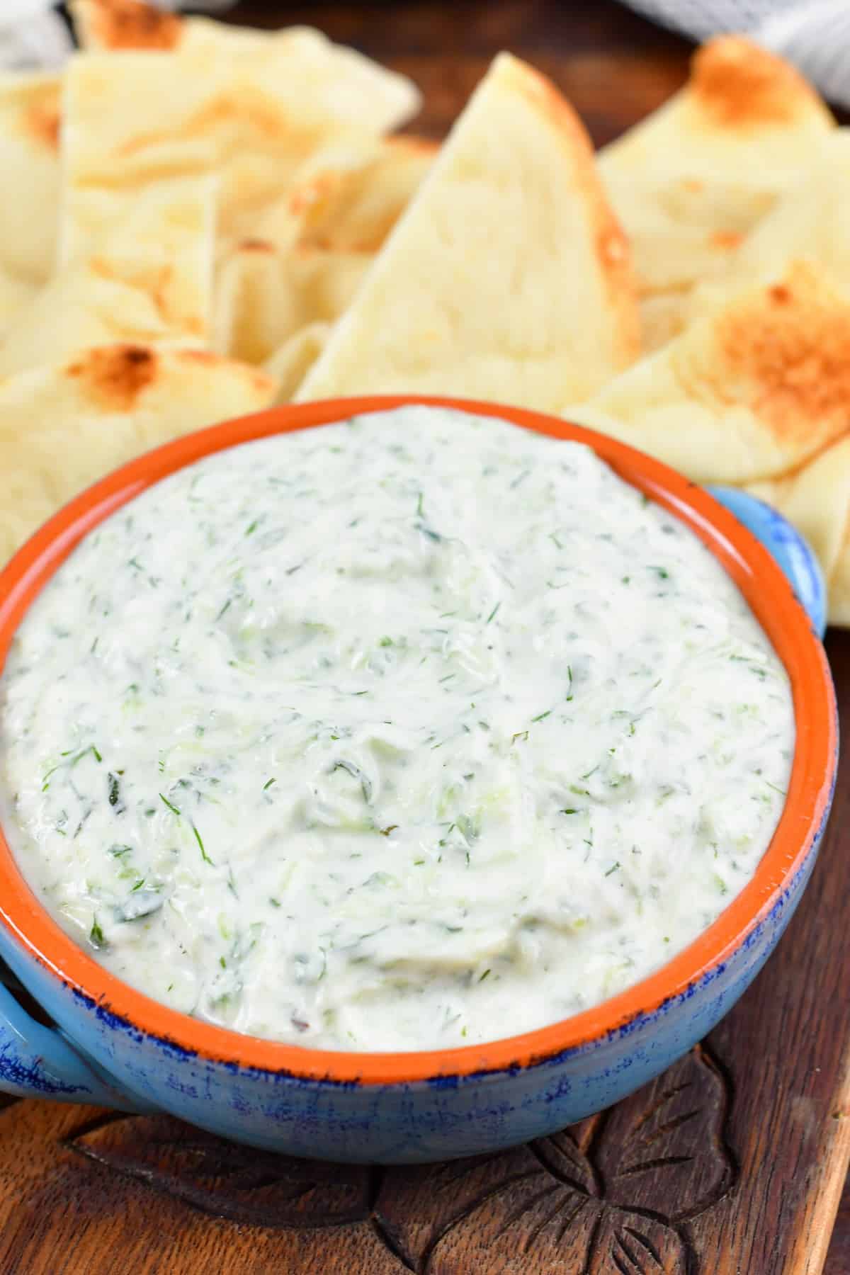 tzatziki sauce in a bowl with pita pieces around