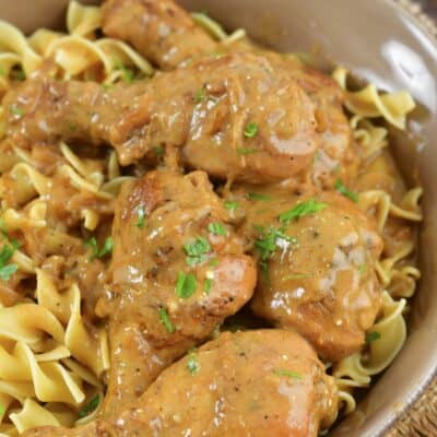 top view of chicken legs in sauce over egg noodles