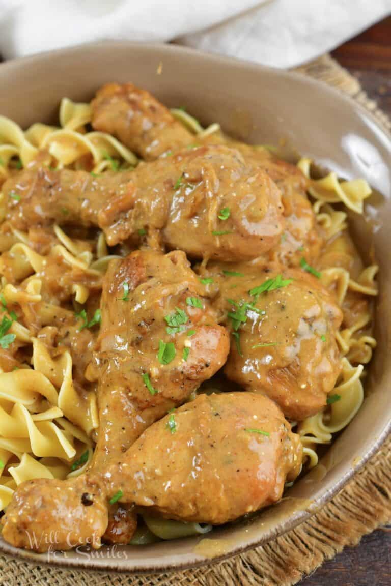 top view of chicken legs in sauce over egg noodles