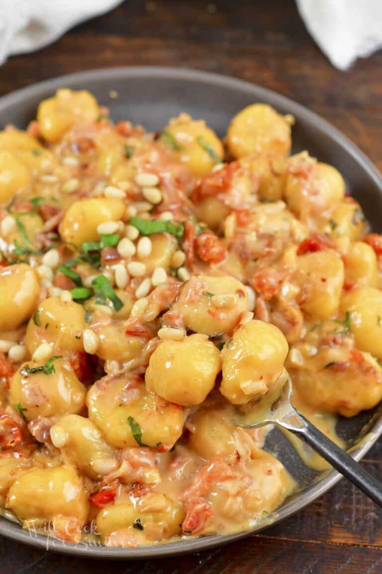 scooping some creamy gnocchi from the plate