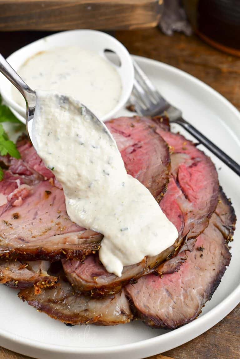 spreading some horseradish sauce over the prime rib.