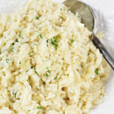 closeup top of parmesan rice in a white bowl.