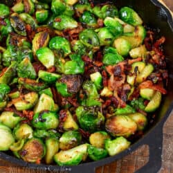squared image closeup roasted brussels sprouts in a skillet.