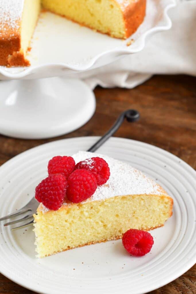 top view of the cake slice on the plate with raspberries on top.
