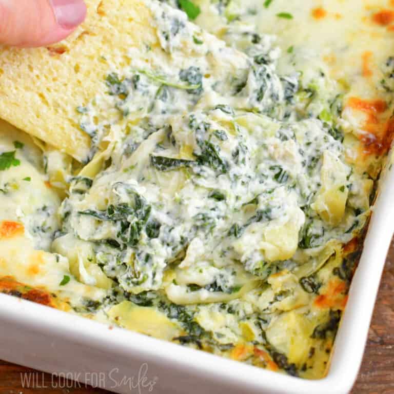 closeup of mixing and scooping spinach artichoke dip.