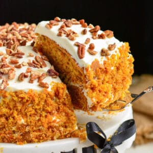starting to take out a slice of carrot cake with a spatula.