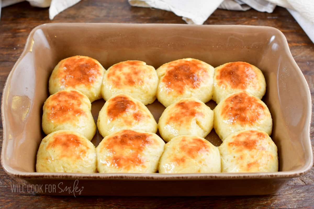 baked dinner rolls in a brown baking dish.