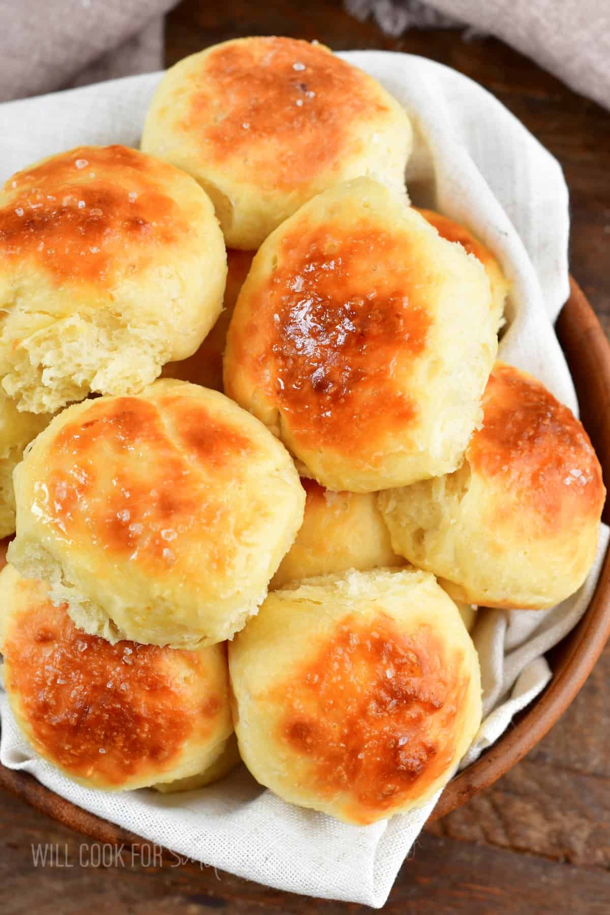 top closeup of several rolls in a bowl with a towel.