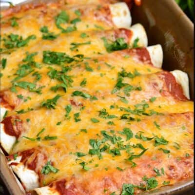 baked beef enchiladas topped with cilantro in a brown baking dish.