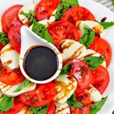 layered tomatoes and mozzarella cheese slices with basil leaves and balsamic reduction.