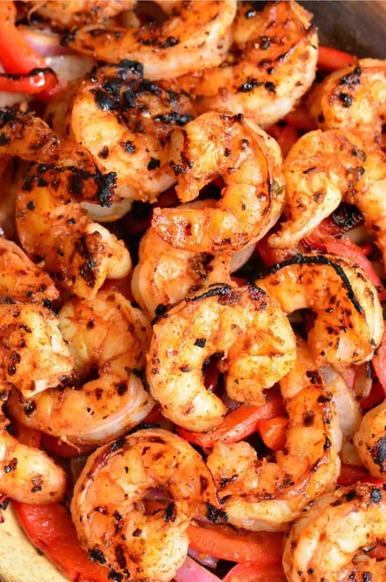 several cajun grilled shrimp on top of onions and peppers