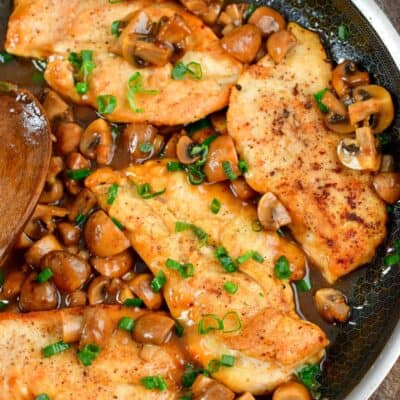 four chicken cutlets in the pan with mushrooms and marsala sauce.