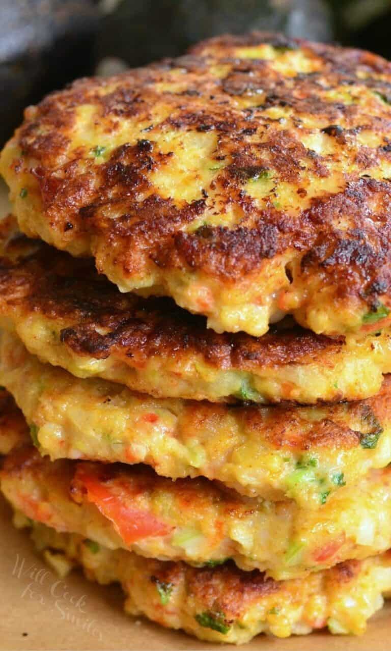 a stack of five shrimp burgers on parchment paper up close.