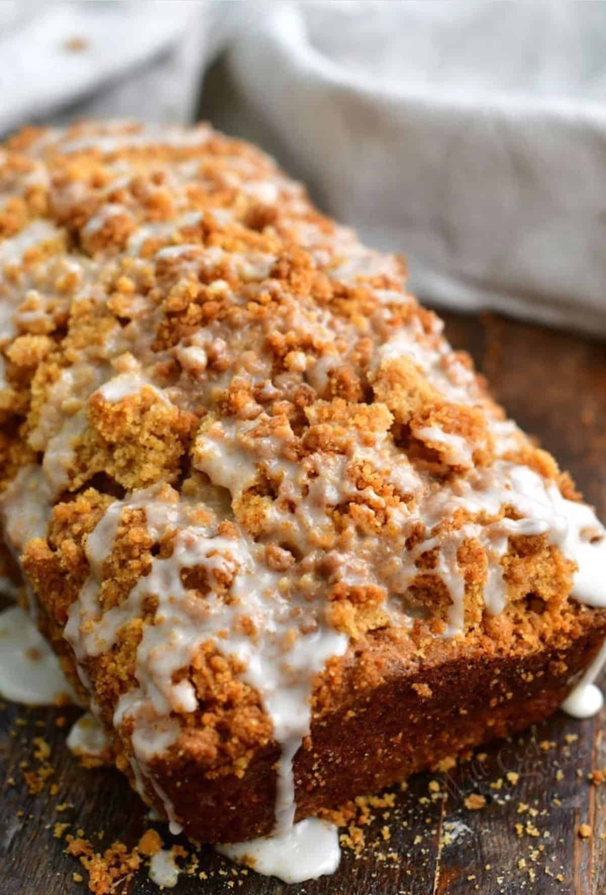 baked zucchini bread with streusel on top and white icing drizzled.