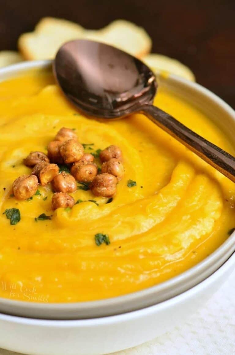 butternut squash in a bowl with chickpeas on and a spoon across the bowl.