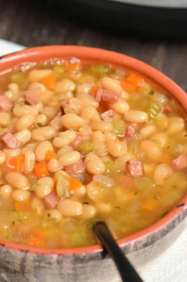 ham and bean soup in a bowl with a spoon scooping some out.