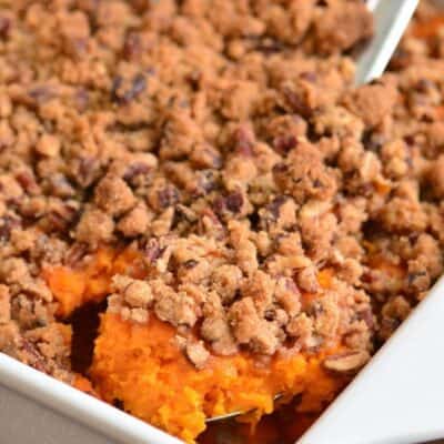 scooping out some sweet potato casserole with sweet pecan crumble on top.