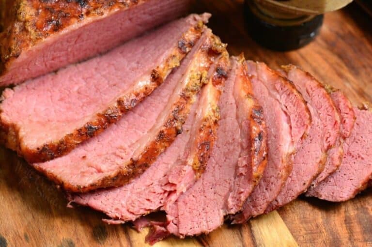 Sliced corn beef on a wood cutting board.