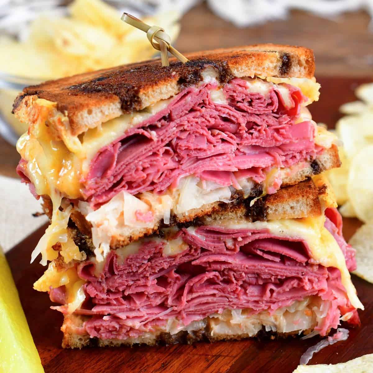 Warm Reuben sandwich cut in half stacked on top of each other.