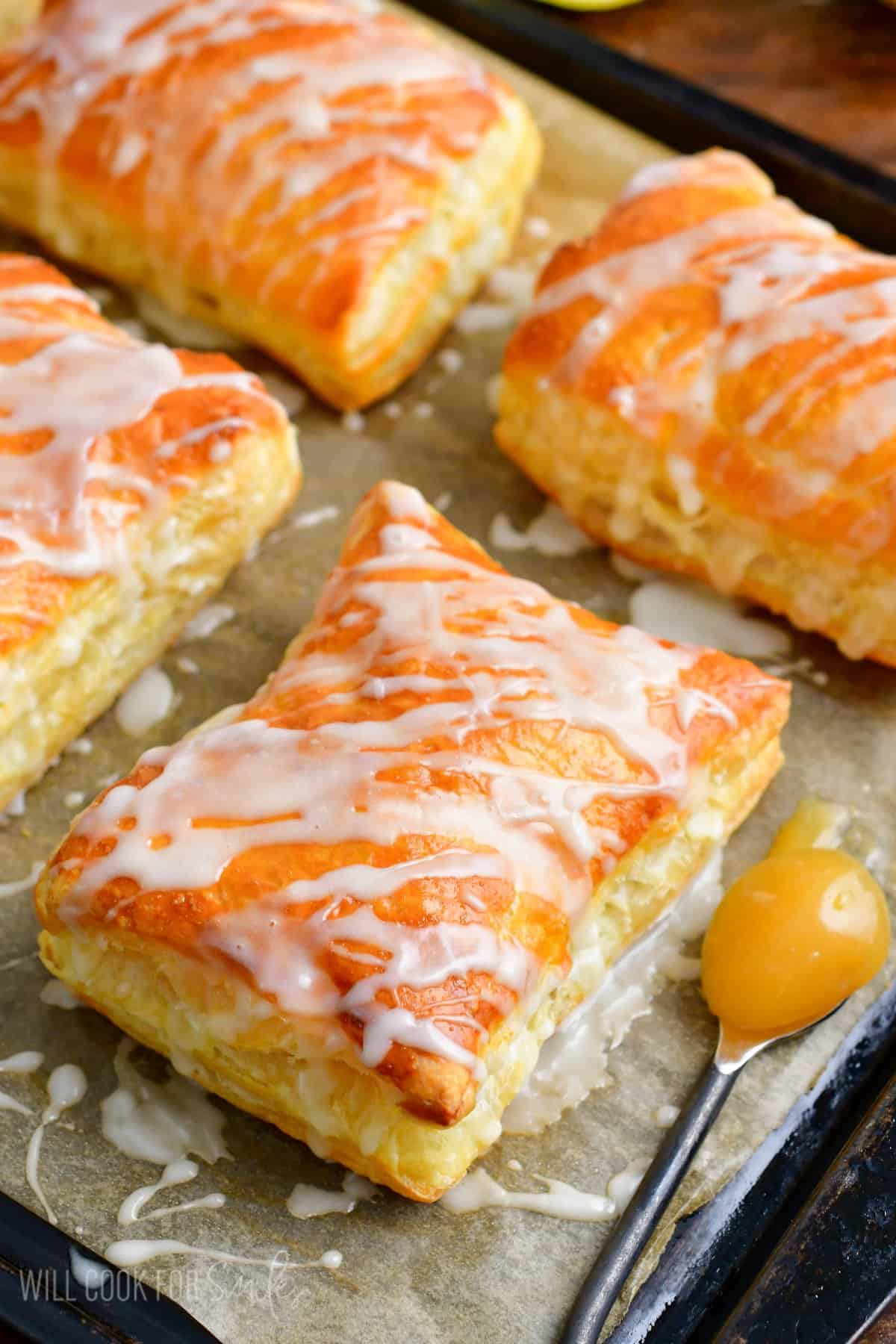 lemon cheesecake hand pies on a parchment paper lined baking sheet.