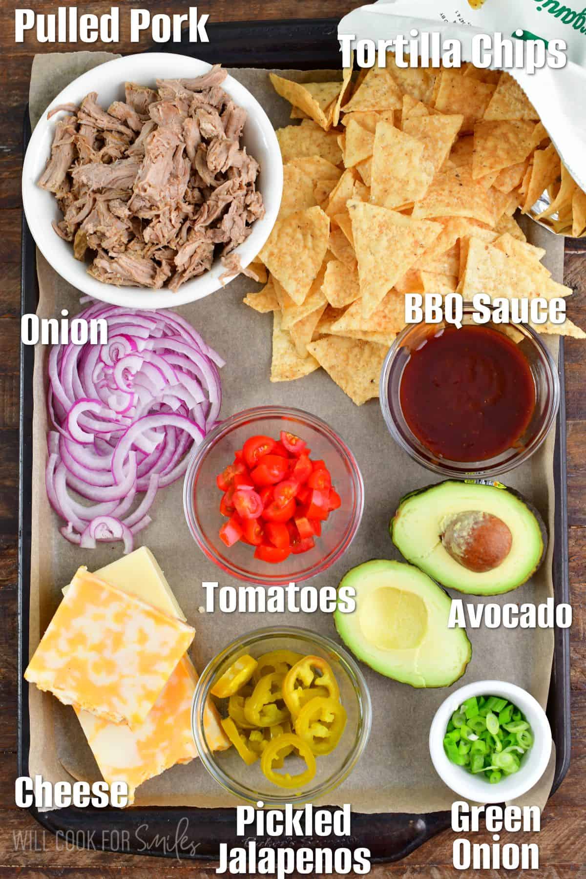 labeled ingredients for pulled pork nachos on a baking sheet.