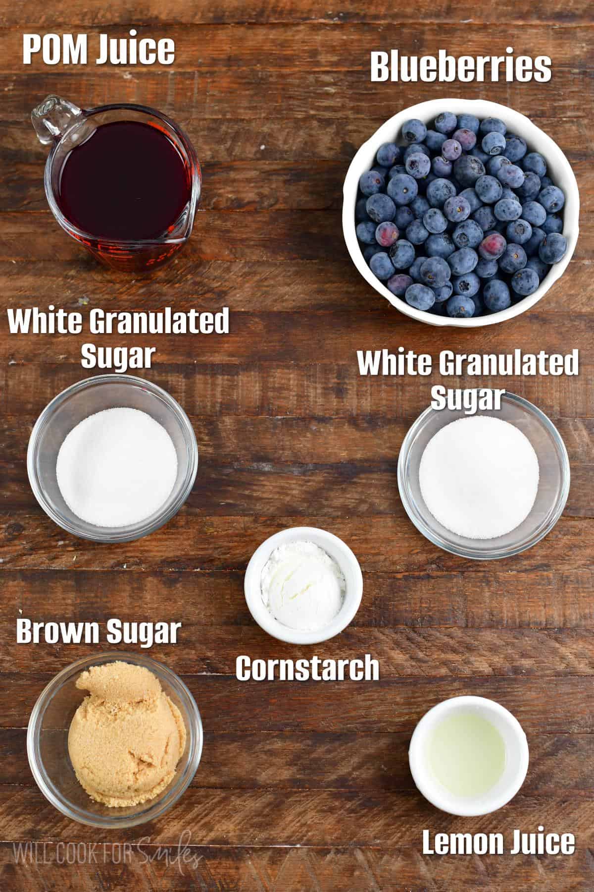 labeled ingredients for blueberry syrup on a wood surface.