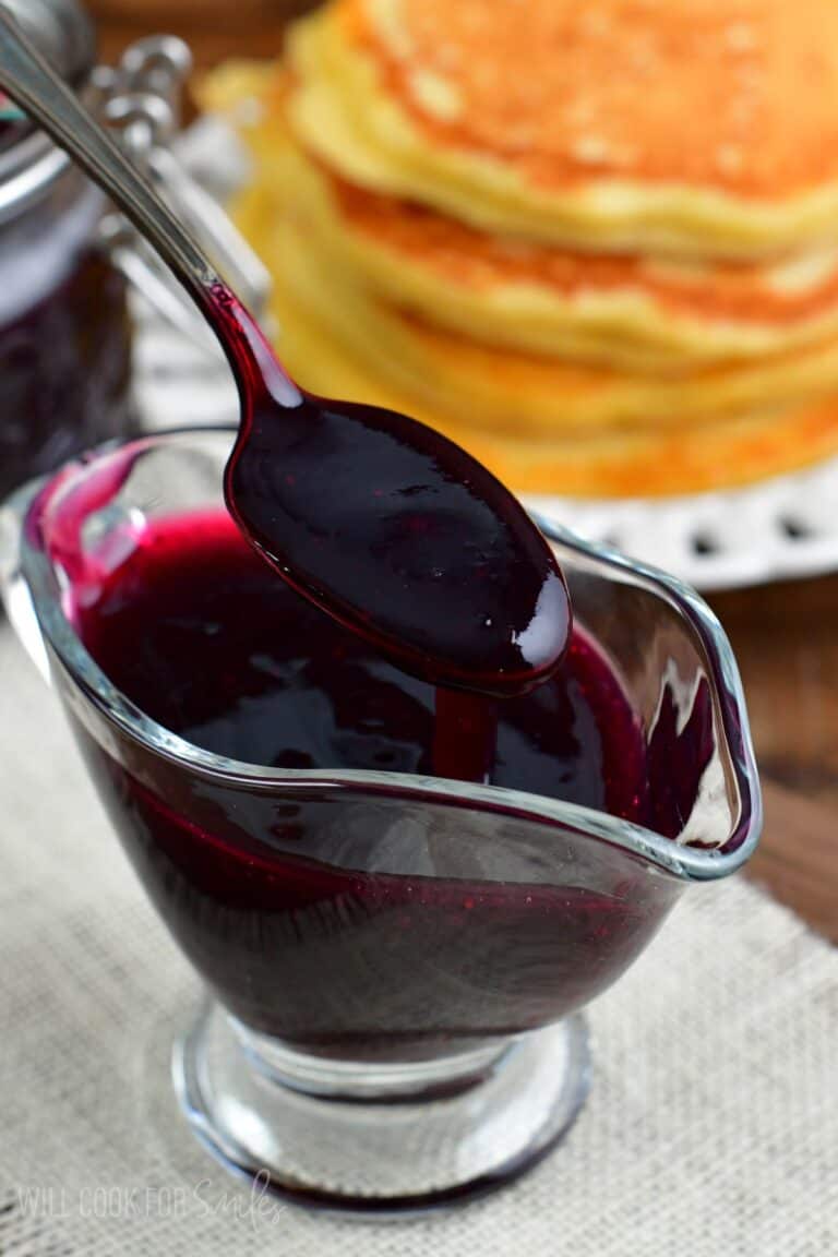 spooning out some of the blueberry syrup out of the saucer.