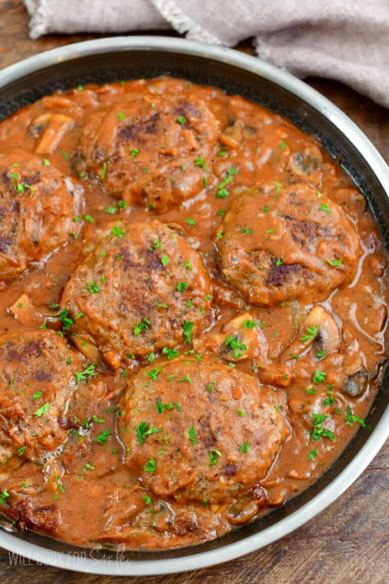 Salisbury Steak in a pan with parsley on top as garnish.