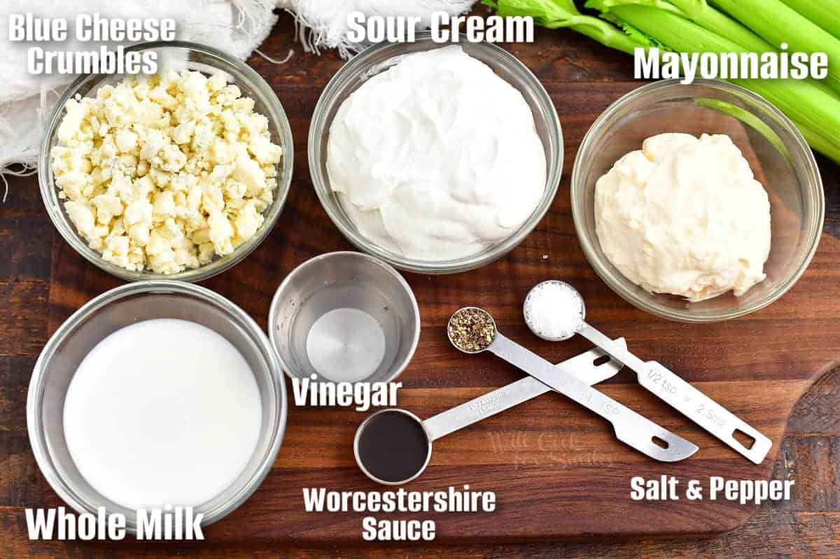labeled ingredients to make blue cheese dressing on a wooden cutting board.