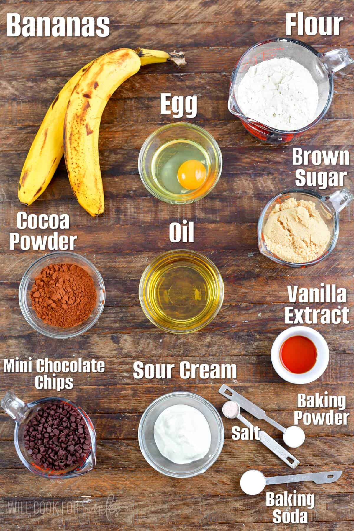 labeled ingredients to make chocolate banana muffins on a wooden board.
