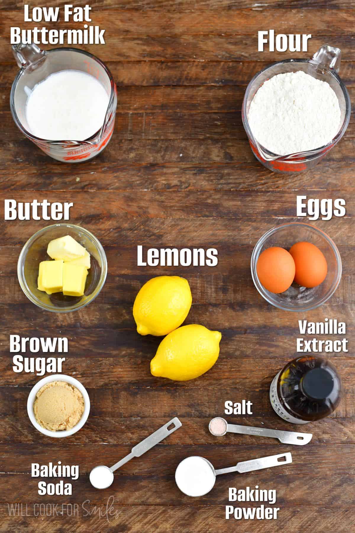 Labeled ingredients for lemon pancakes on a wood surface.