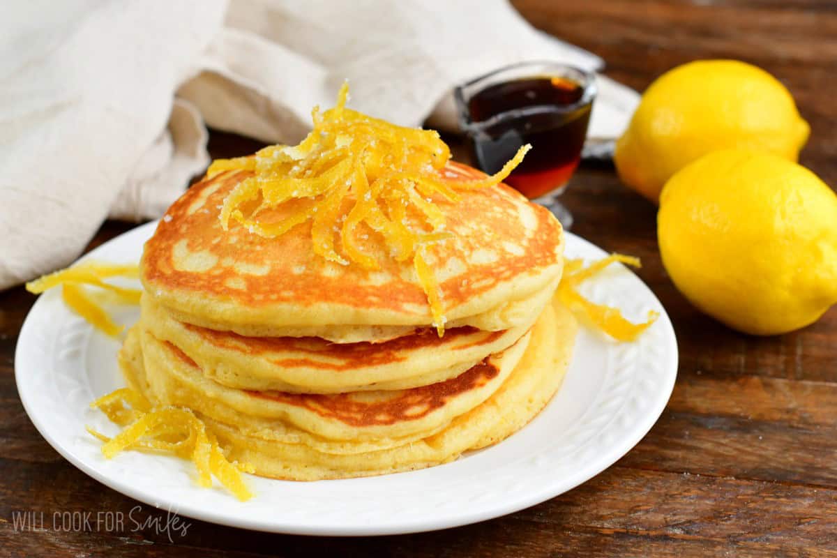 Lemon pancakes on a plate with candied lemon on top.