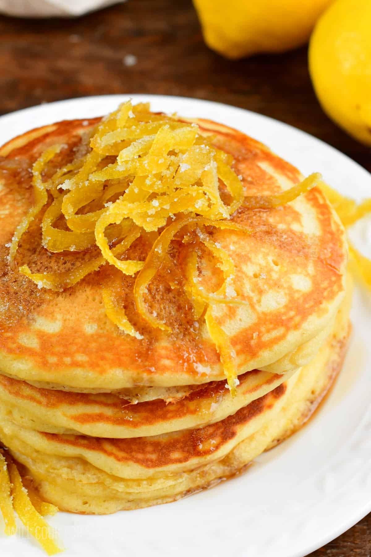 Lemon pancakes with lemon peels on top.