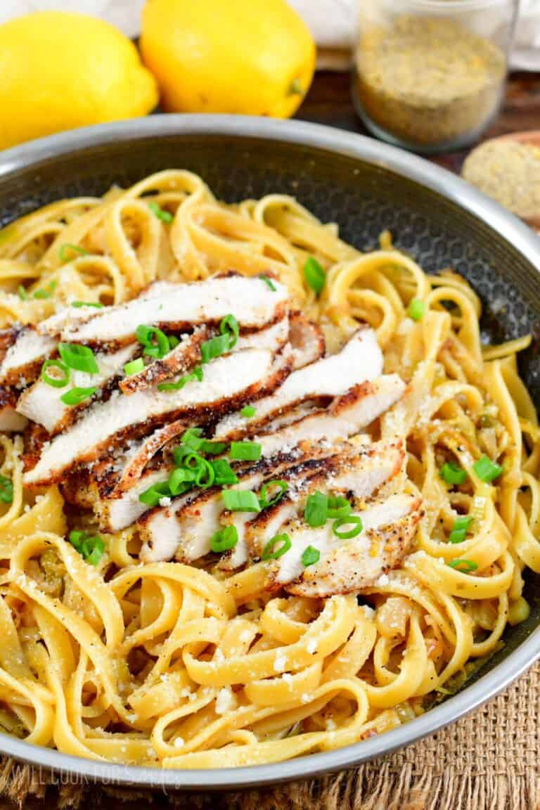 Pasta with lemon pepper chicken over top in a pan.