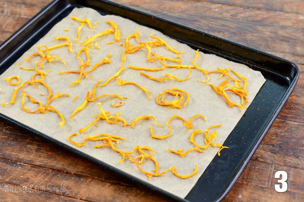 Dried lemon peels on a wax paper lined baking sheet.