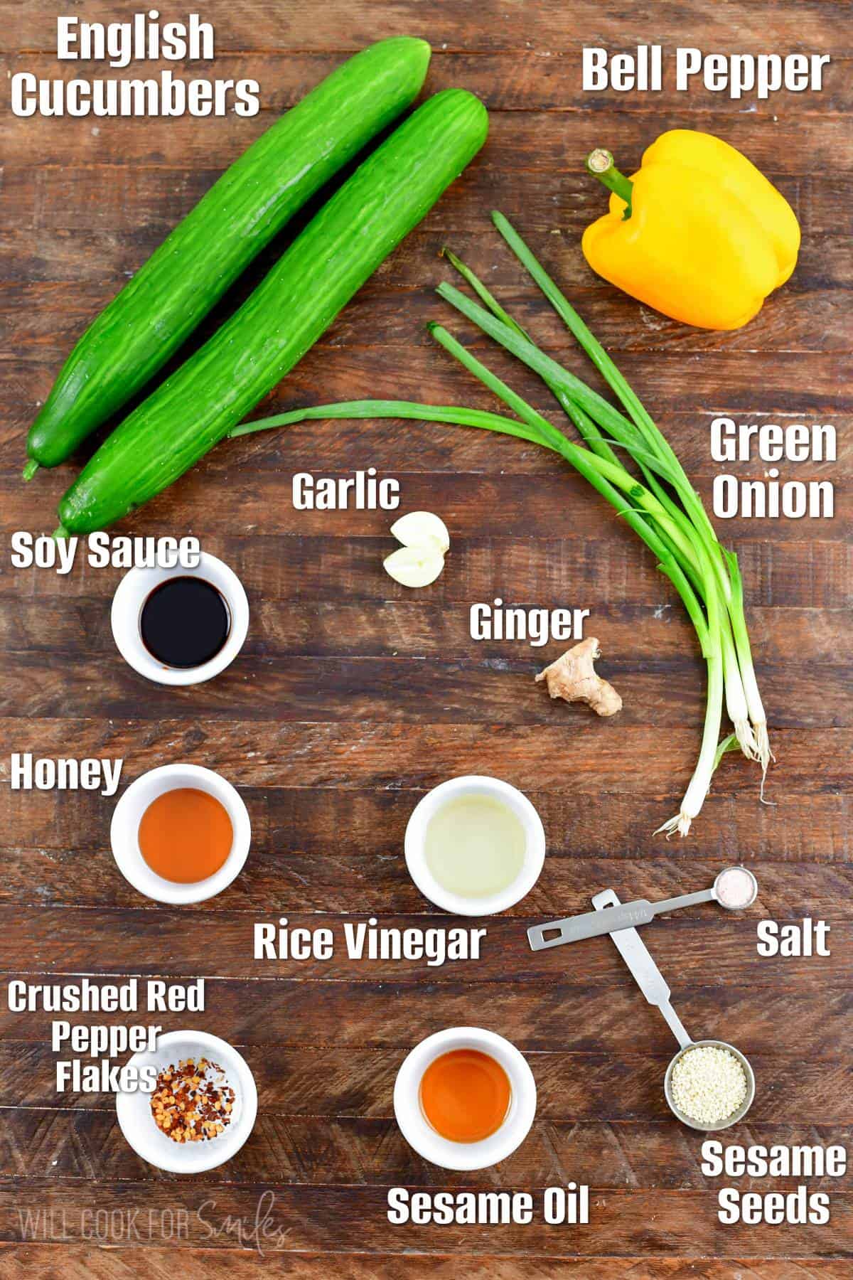 Labeled ingredients for Asian cucumber salad on a wood surface.