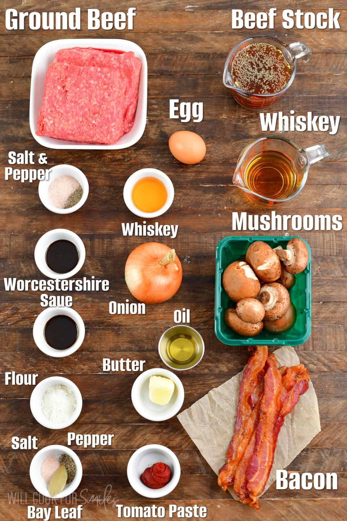 Labeled ingredients for whiskey burgers on a wood surface.