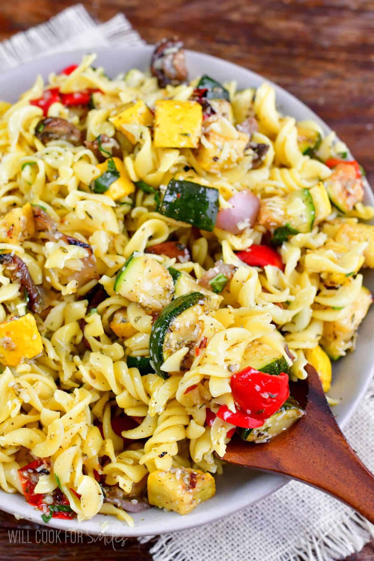 scooping up the Grilled Vegetable pasta salad with a big wooden spoon.