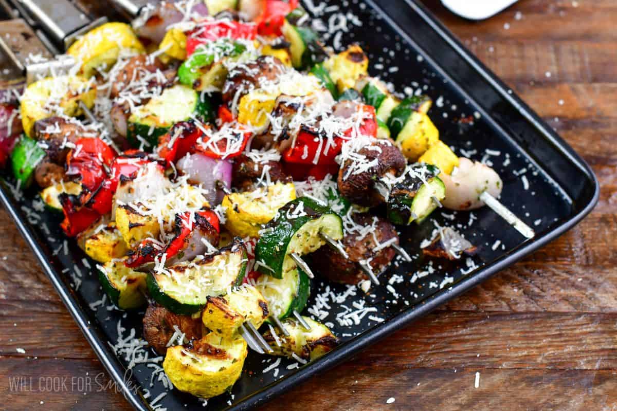 Grilled Italian vegetables cooked and topped with parmesan cheese on a baking sheet.