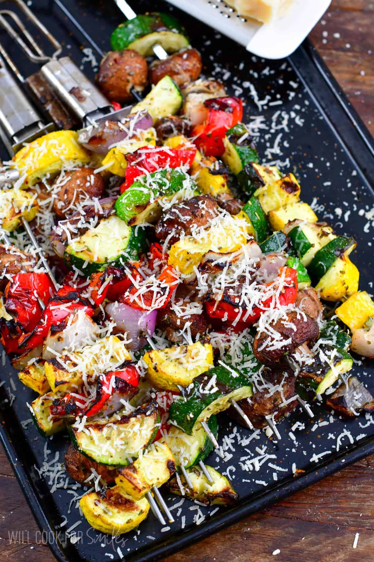 Cooked Italian vegetables on a baking sheet with parmesan cheese sprinkled on top.