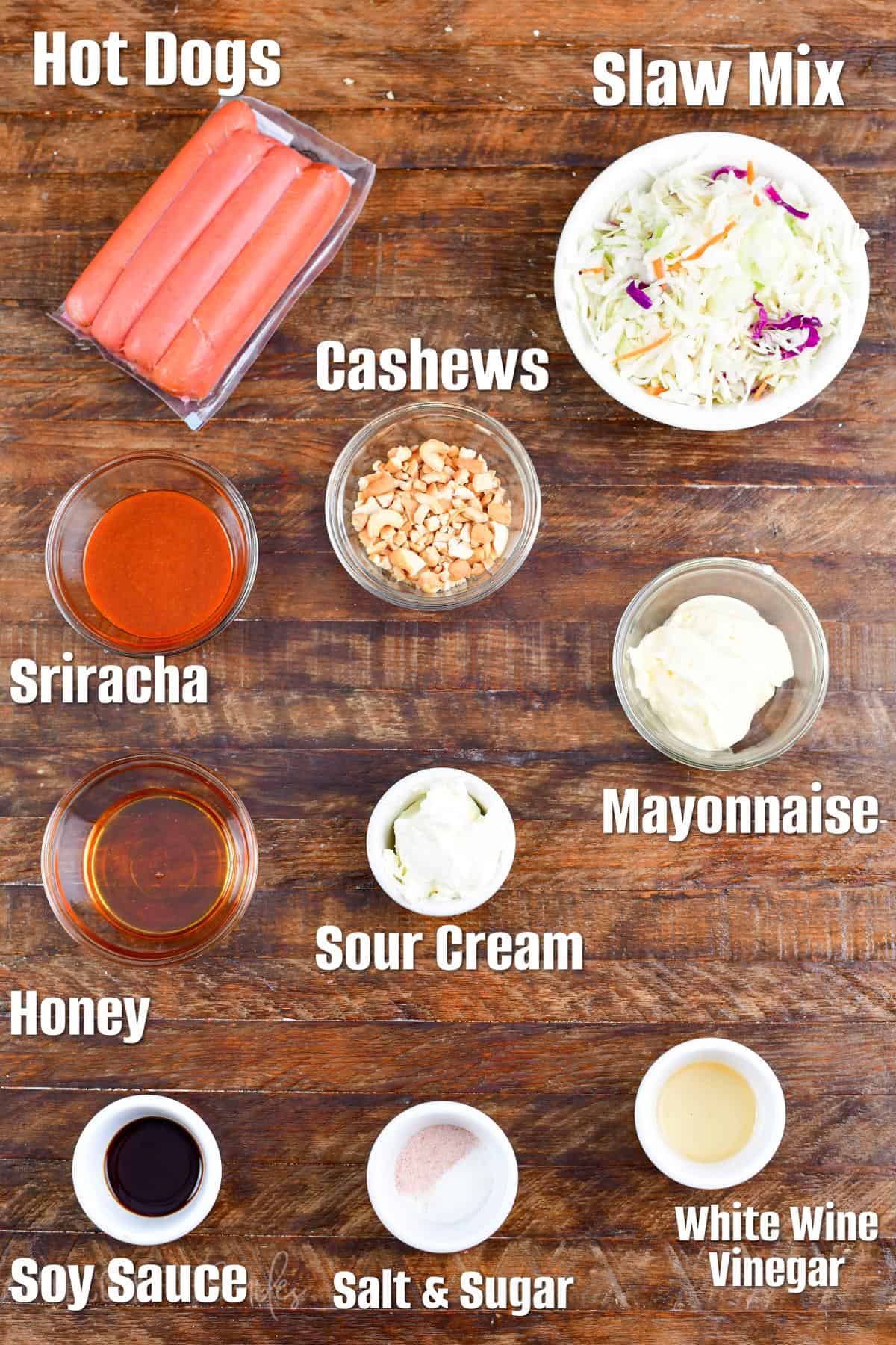 Labeled ingredients for Sriracha Honey Hot Dogs on a wood surface.